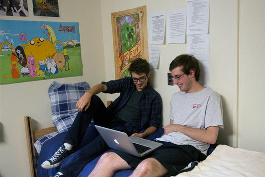 college roommates smiling looking at the laptop screen