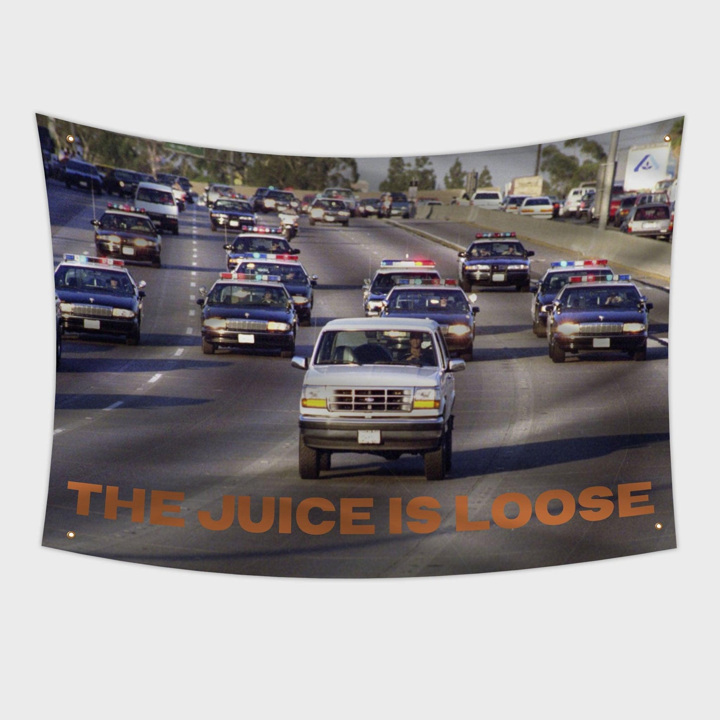 OJ Simpson driving his bronco down the freeway with police chasing him "The Juice is Loose" flag